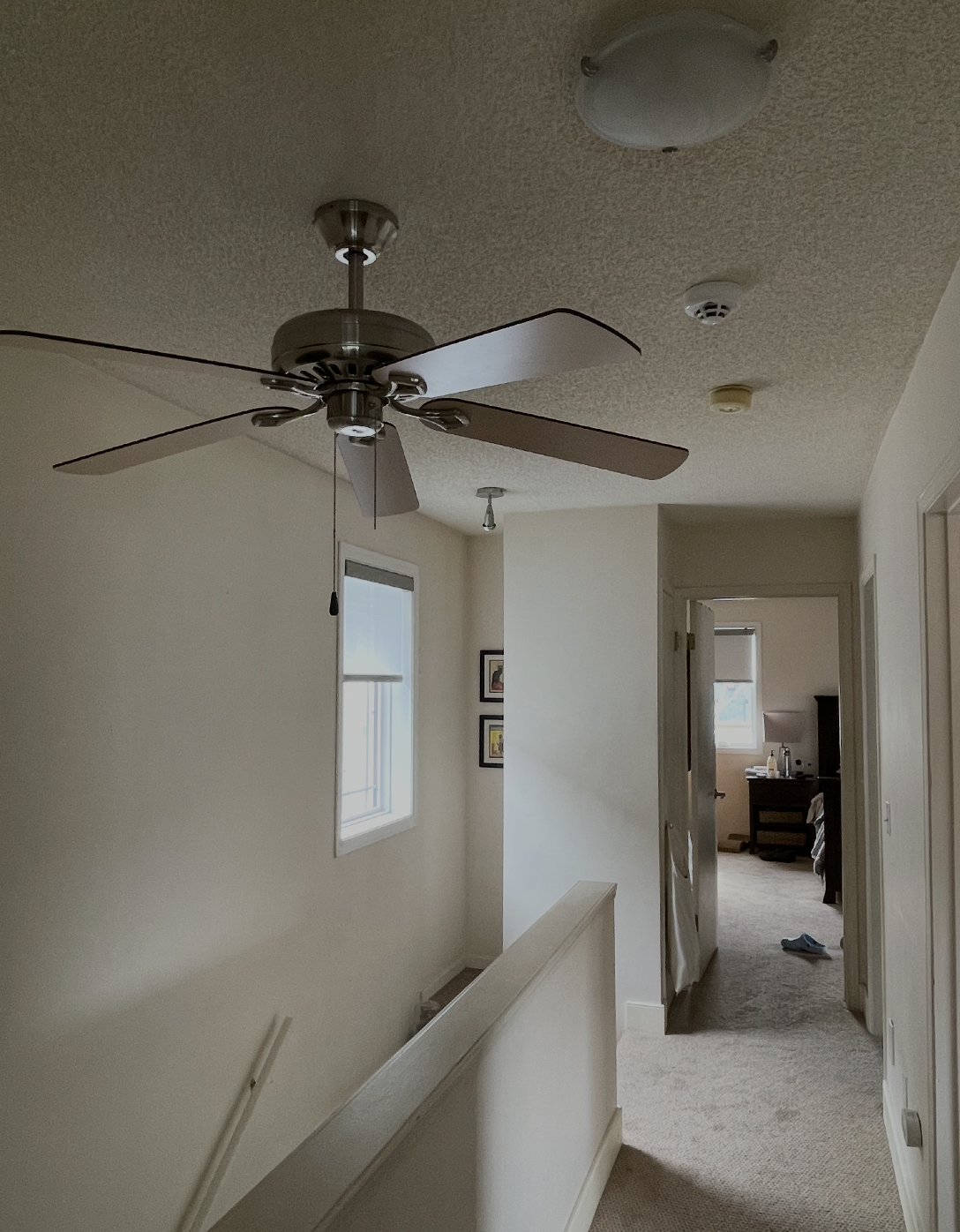 Dated upstairs hallway with popcorn ceiling and beige walls before painting